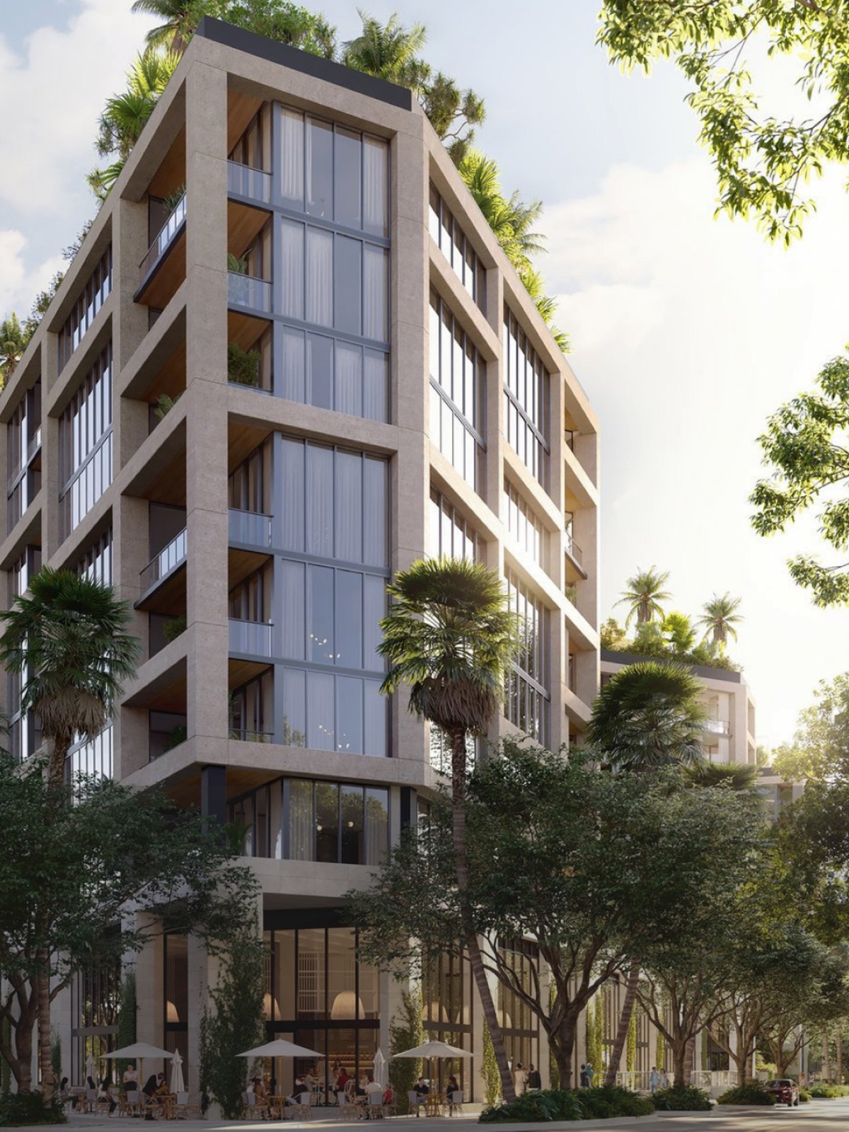 A stone and glass residential building framed by palms and mature tree canopy in Coconut Grove