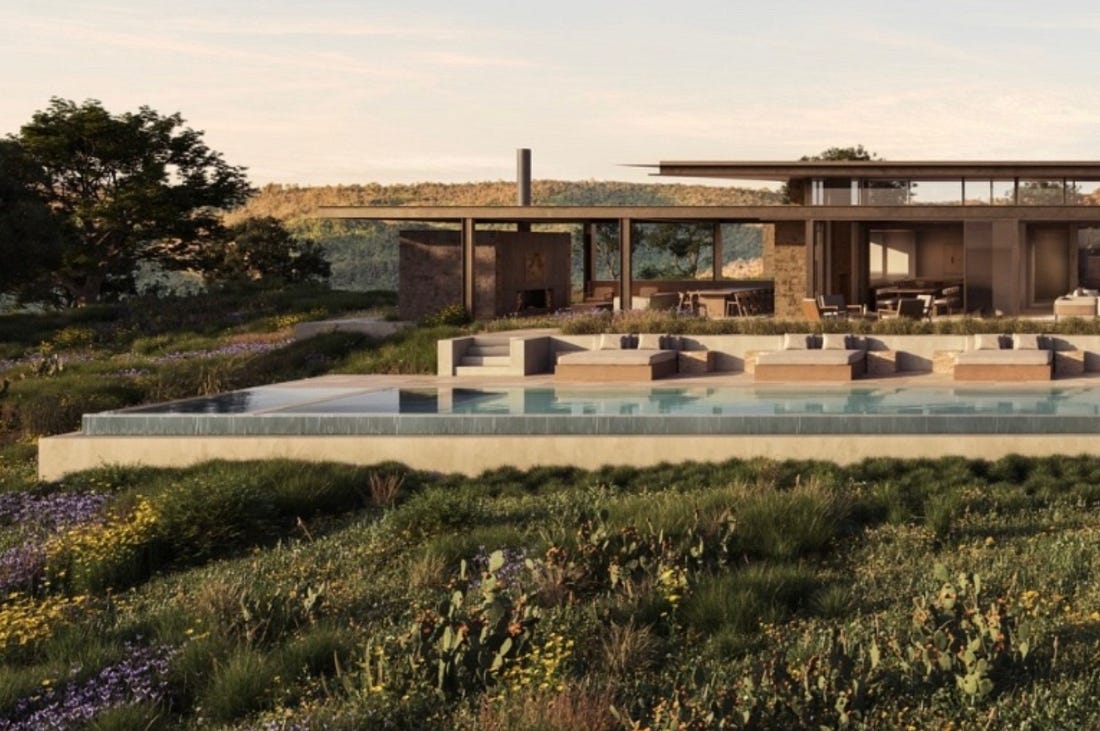 A low-slung contemporary residence with an infinity pool, set in a wildflower meadow at golden hour