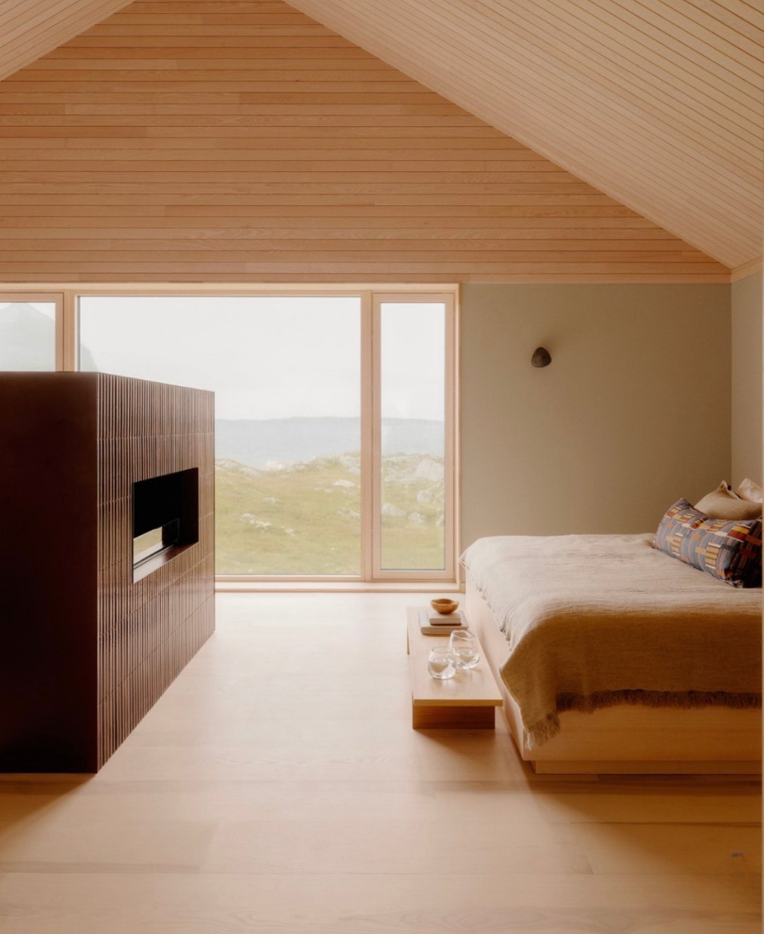 A suite with a freestanding fireplace, oak floors and a low bed facing the moorland
